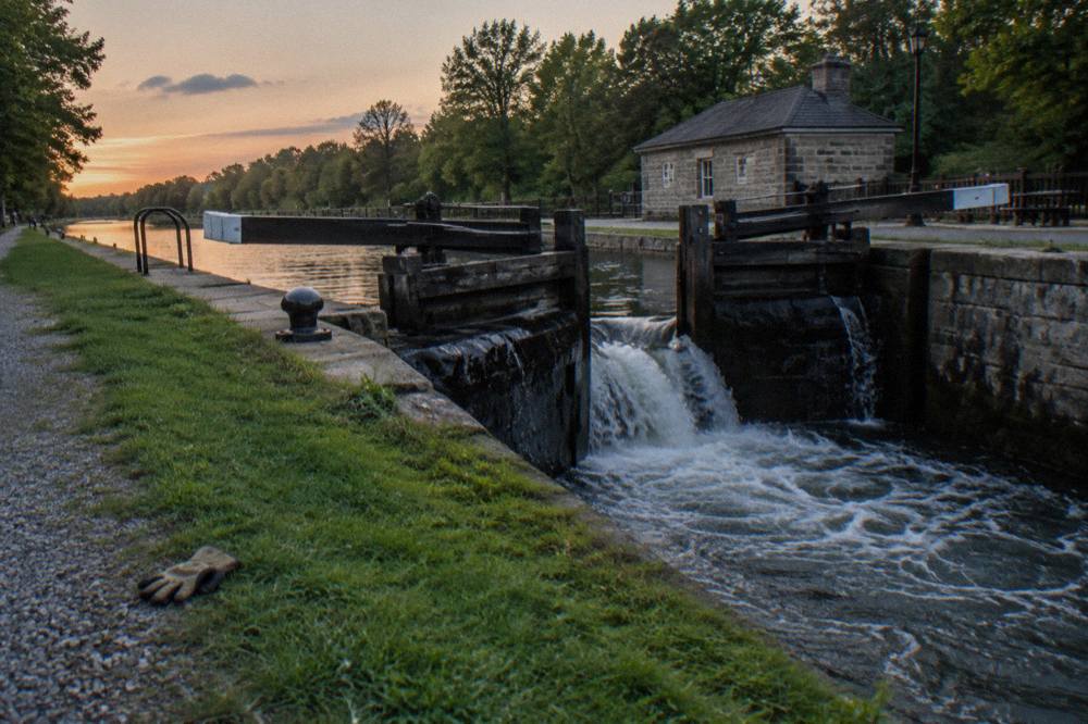 A lock gate on the Erie Canal with water pouring through the opened gates