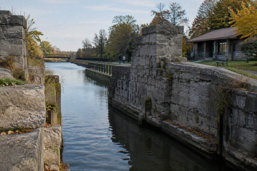 Restored stone heritage lock gates standing dry beside the modern canal