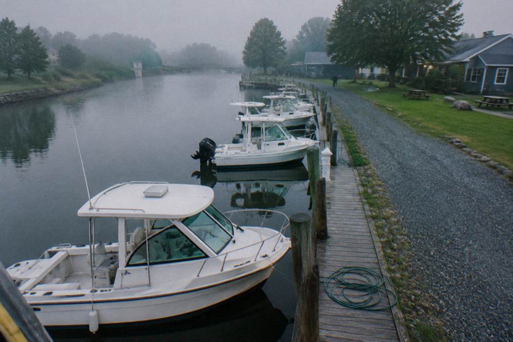 A fleet of small canal charter boats moored in a row at a marina basin