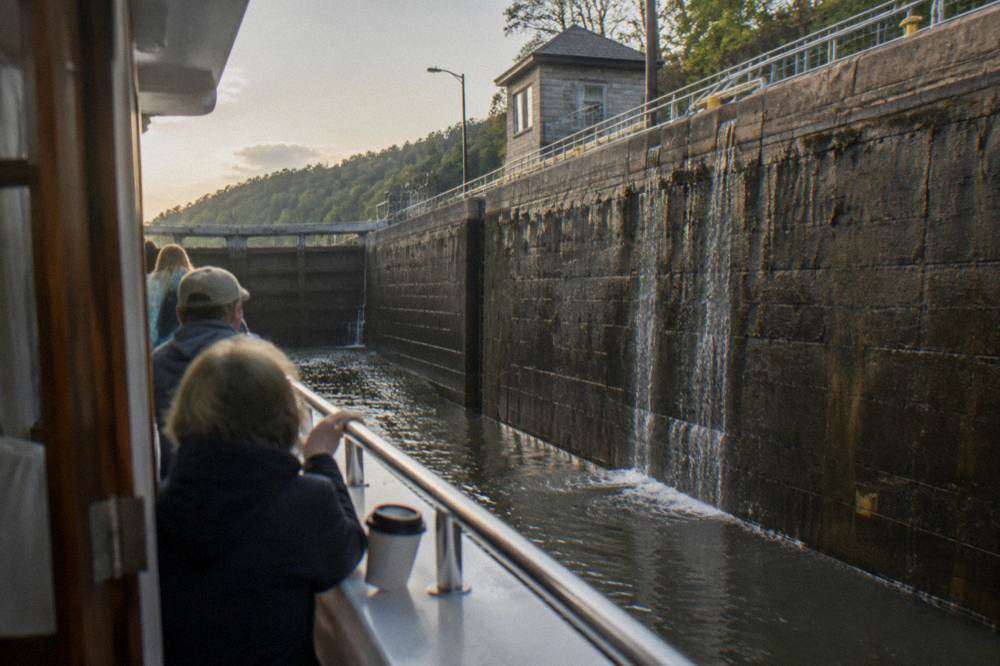 A cruise boat inside a lock chamber with passengers watching the water rise