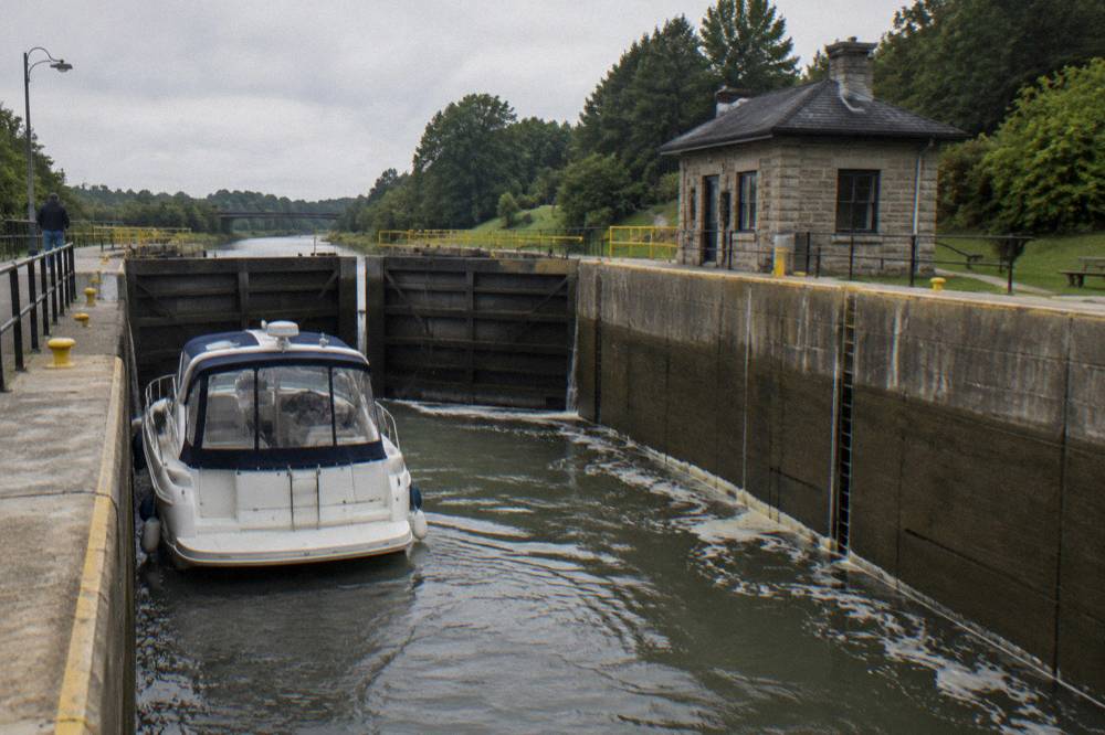 A canal boat entering a lock chamber with gates closing behind it.