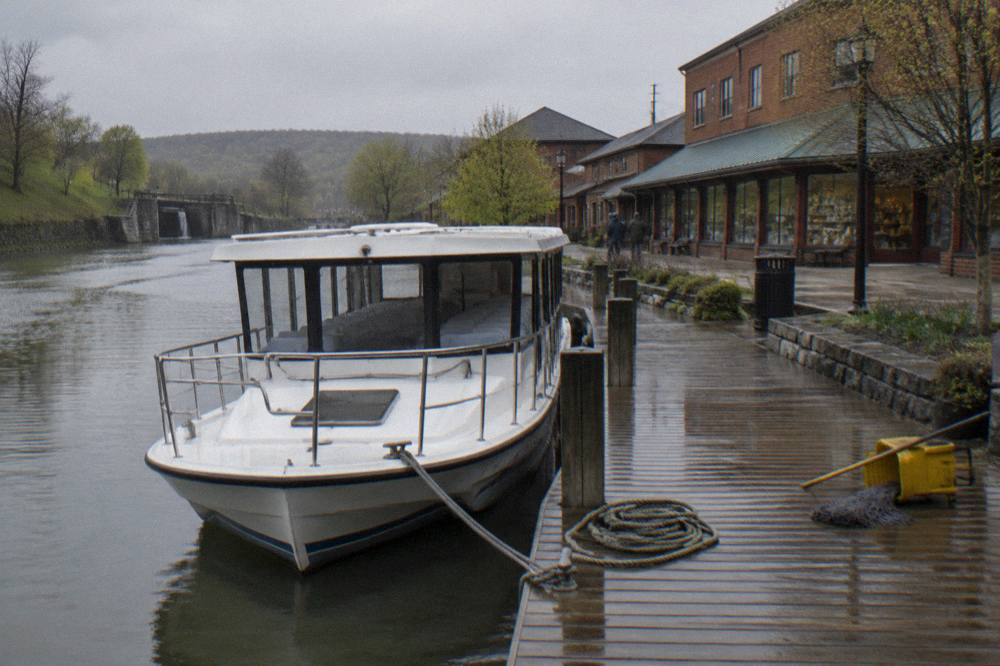 A sightseeing cruise boat docked at a canal-side landing