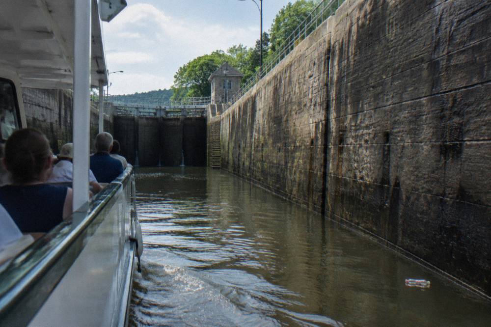 A boat rising inside a canal lock between tall stone lock walls