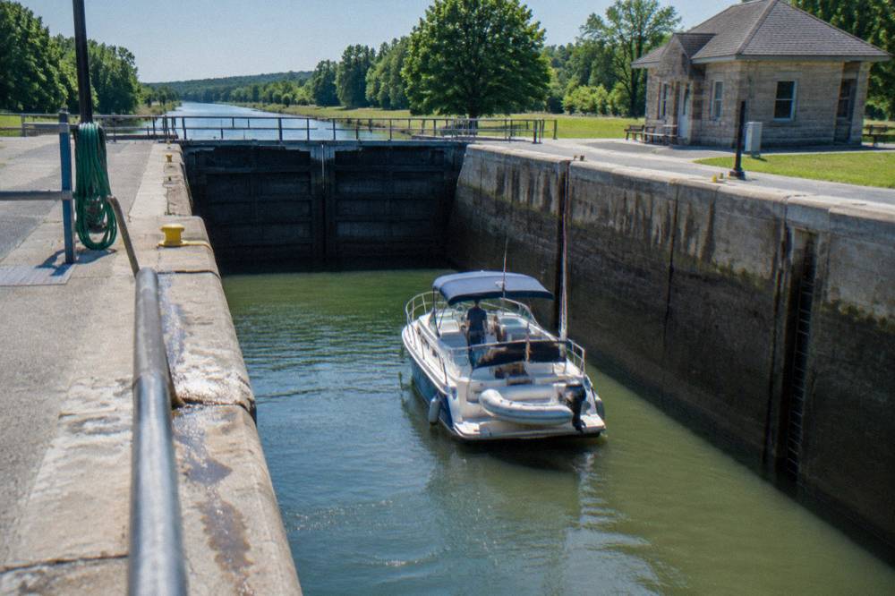 A boat sitting in a canal lock chamber with gates closed and water at mid-level