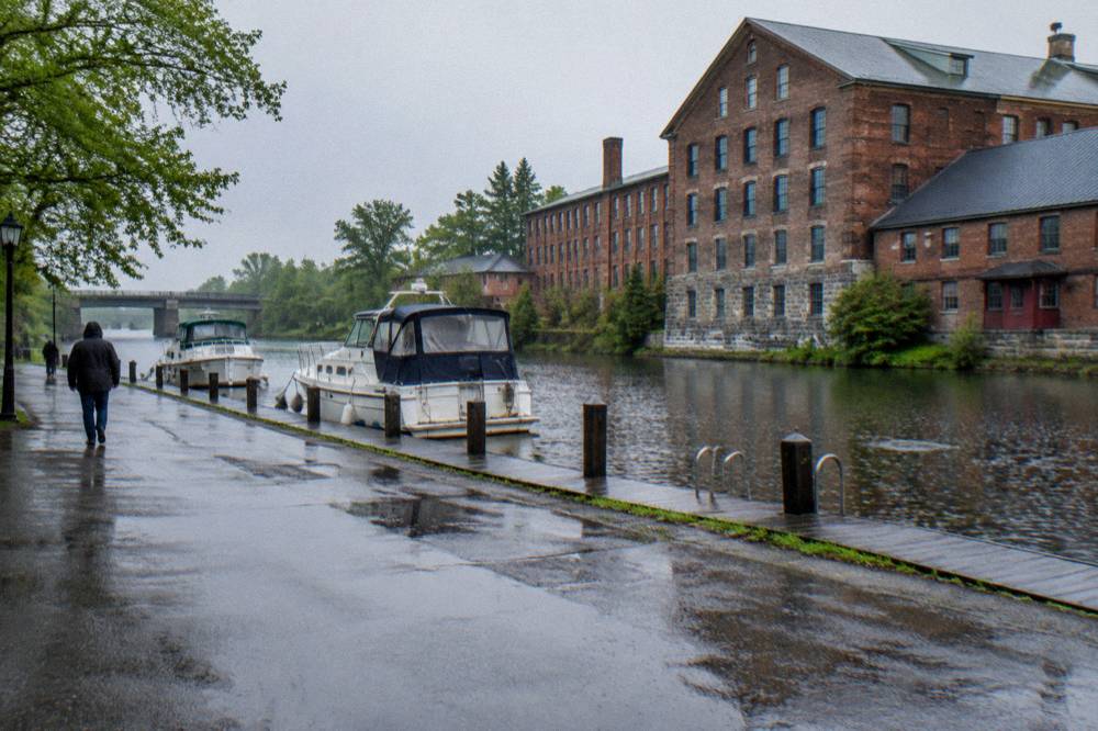 A village main street meeting the canal bank with a dock and moored boats