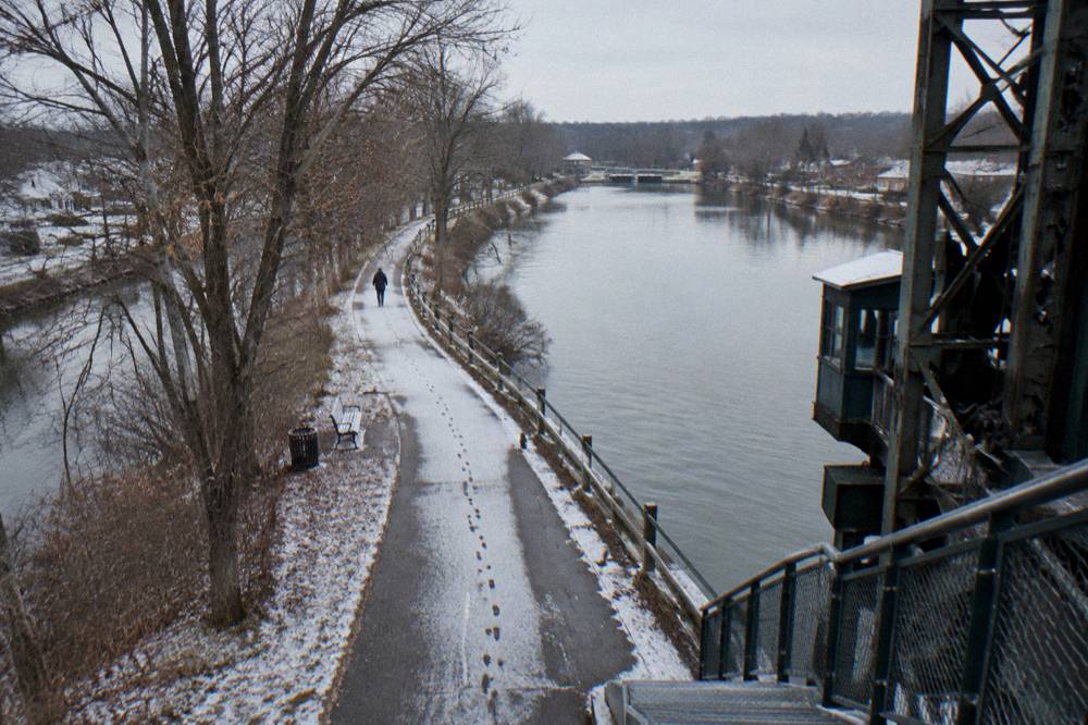 Empty canal-side path curving past a lift bridge