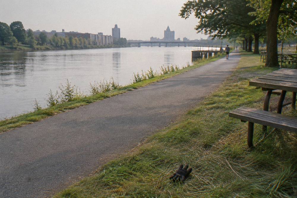 Packed stone dust towpath trail running straight beside the canal with a lift bridge in the distance