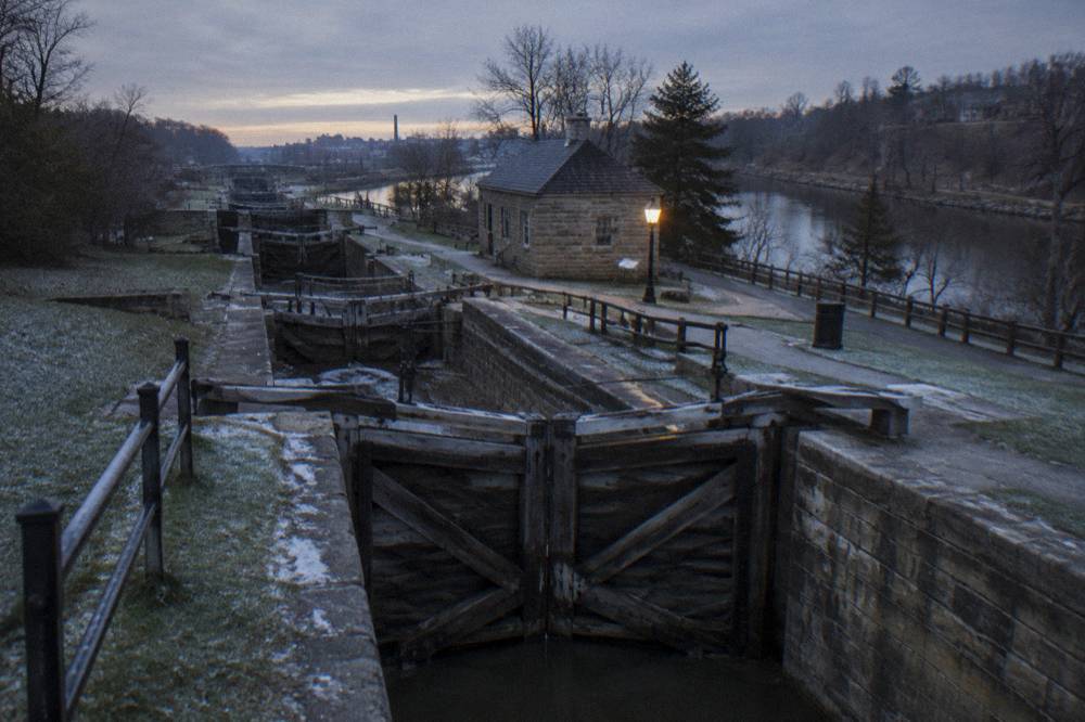 Restored nineteenth century wooden lock gates of the Flight of Five beside a stone canal wall