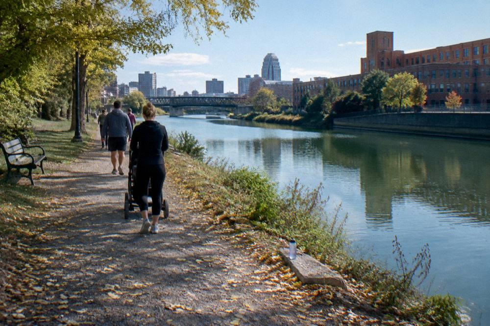 A towpath trail beside a canal with cyclists and green water